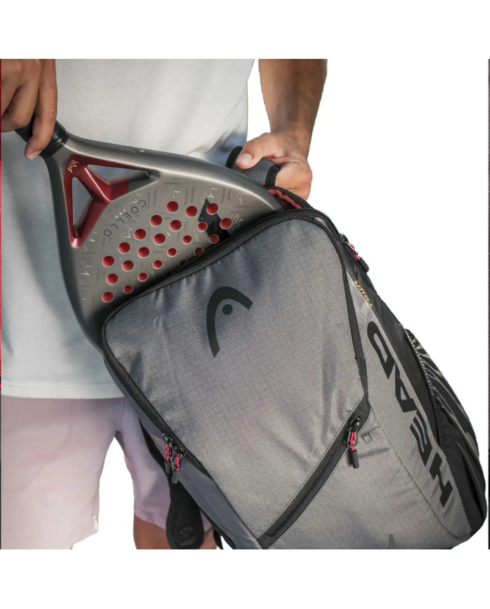 Alto focus su una mano che sistema una racchetta da tennis in una tasca di uno zaino da tennis moderno Heah BackPack Coello Tour