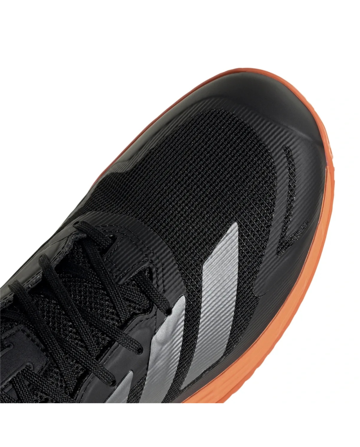 Scarpa da tennis adidas nera con dettagli grigi e suola arancione, taglio moderno e tomaia in mesh.