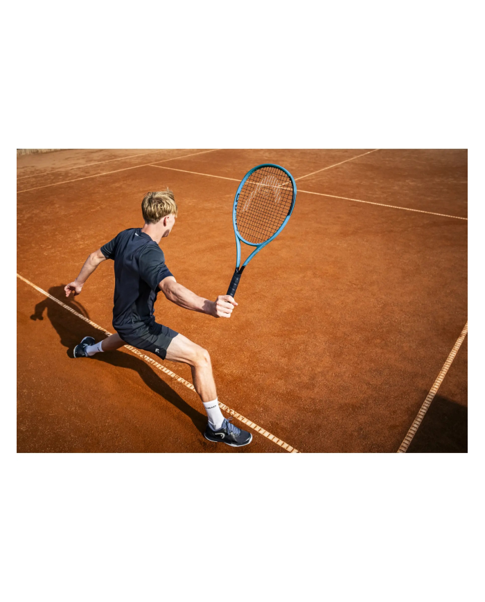 Giovane giocatore di tennis in azione su campo in terra rossa, colpisce la pallina con racchetta blu. Alt text contiene Head Boo